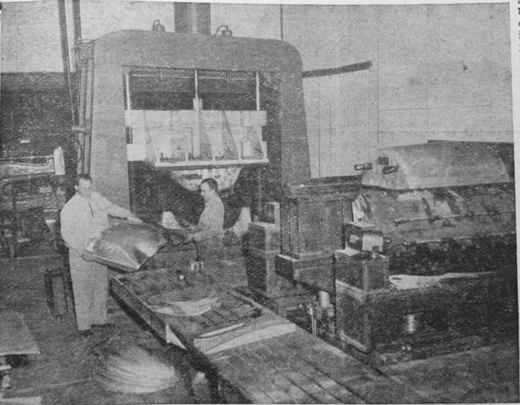 ERCOUPE PARTS COMING OFF THE STAMP PRESS – J.E. inspects bottom cowl stamping that has just come off the Drop Hammer. To the right may be seen the company's hugh stretch press.