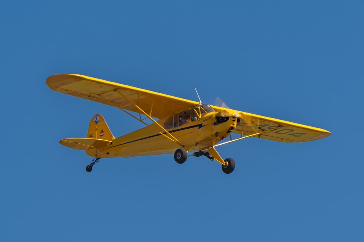 Vintage yellow Piper Cub from the Bob Hoover Academy flying over Salinas