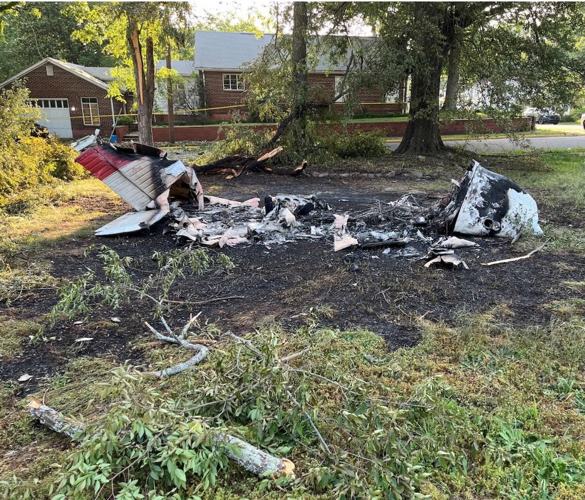 The post-crash wreckage of a Piper PA-28-180 plane crash in a residential neighborhood following an engine failure.