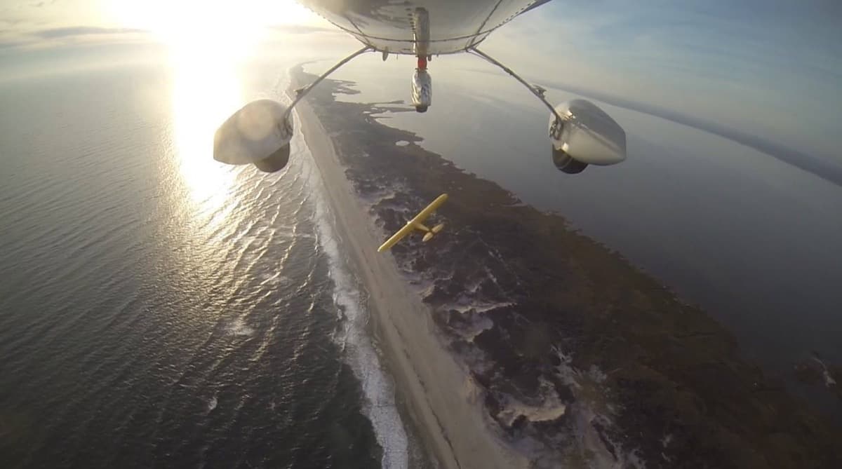 Aerial view from an Aerobat tracking a yellow Cub flying along the beach and coastline of Fire Island, New York.