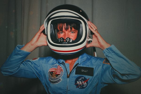 Astronaut Sally Ride smiling in her NASA flight gear, featured in the National Geographic documentary film.