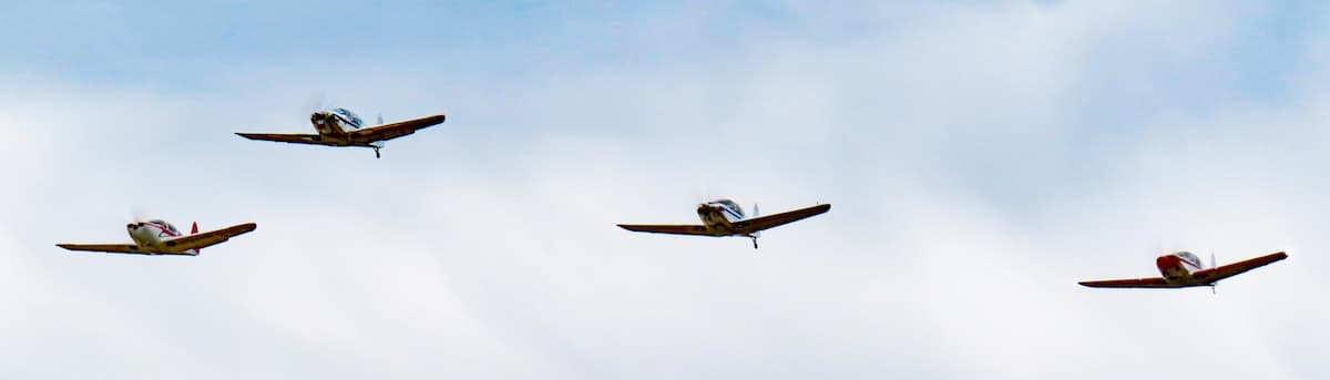 A formation of classic Globe Swift aircraft flying over Texas during the 2026 Swift Nationals Fly-In.